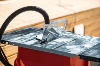 Woodworker focused on table saw amidst swirling dust and sunlight in workshop.